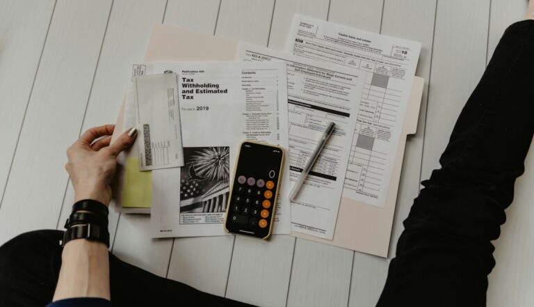 Accountant reviewing documents with a pen and calculator