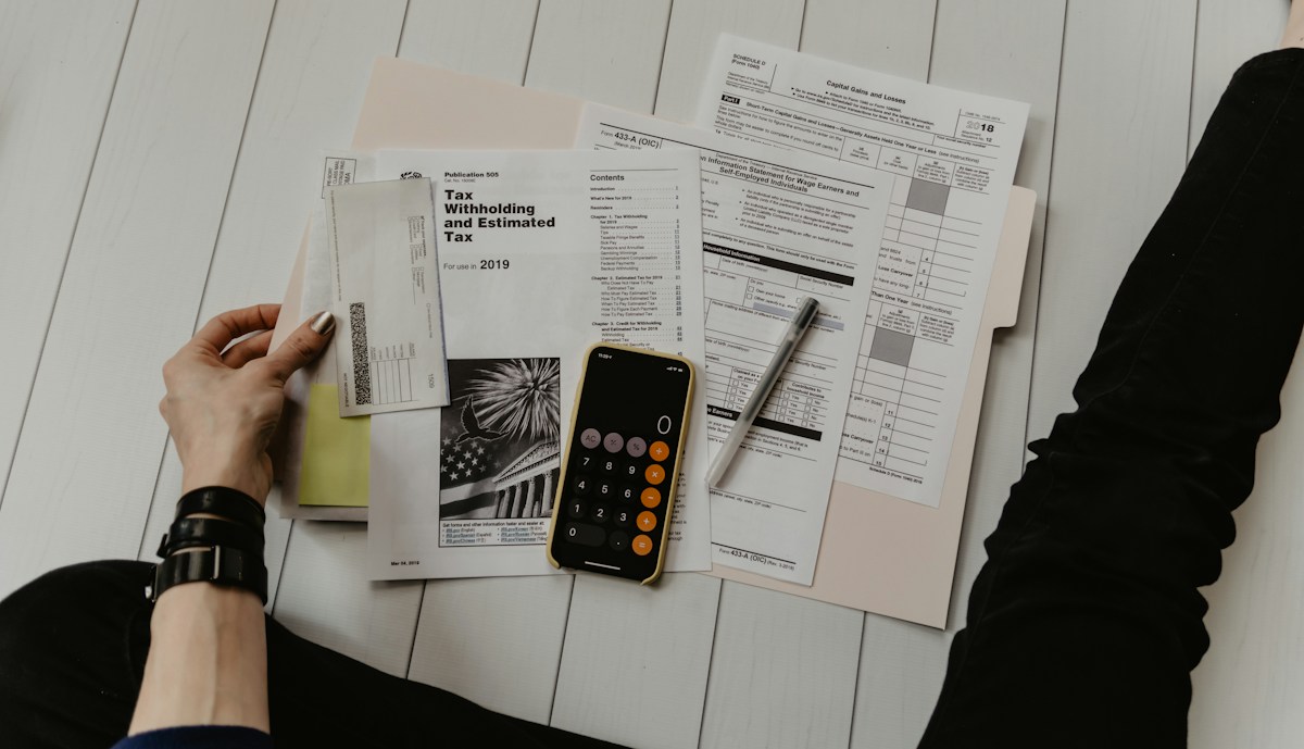 Accountant reviewing documents with a pen and calculator