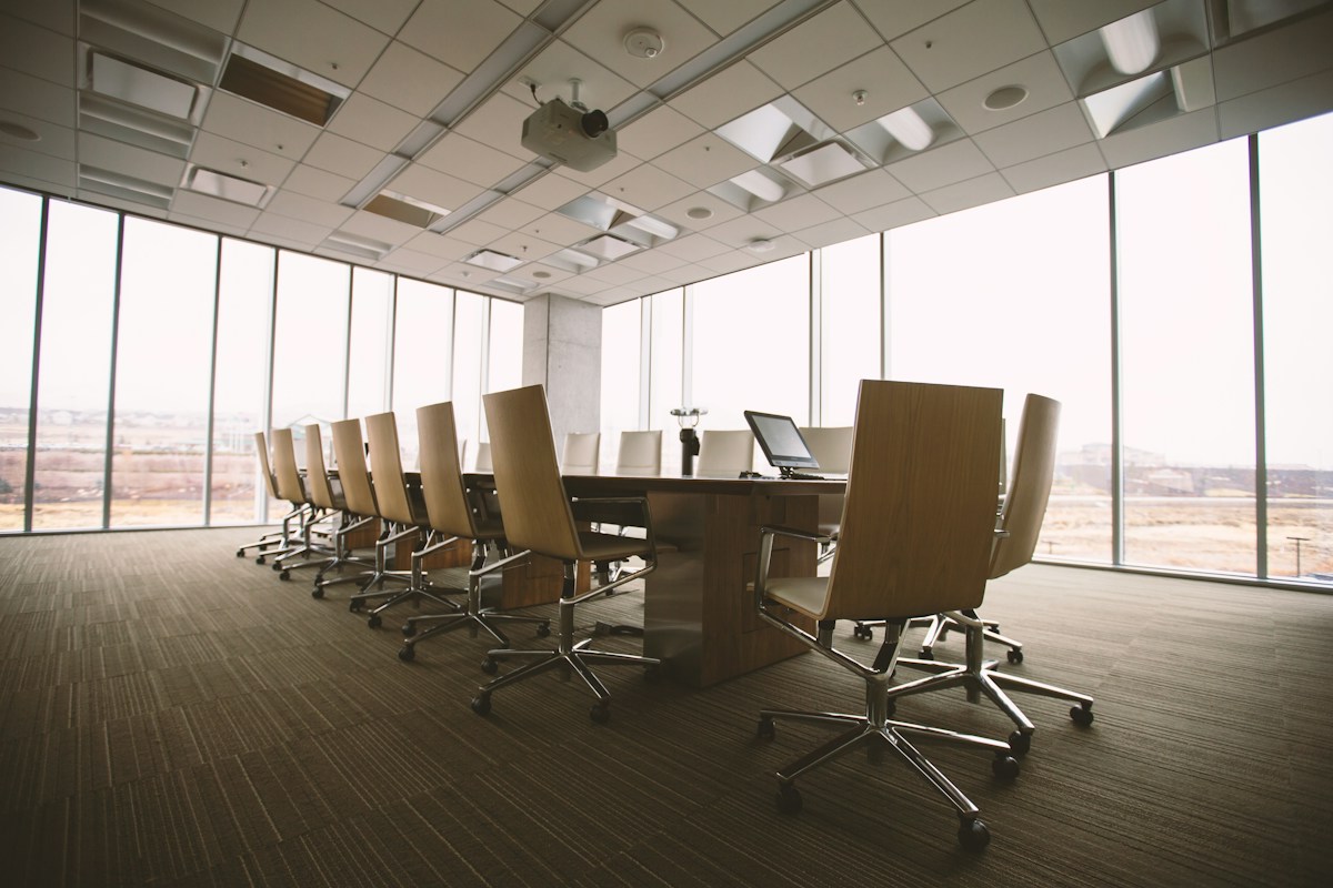 Corporate boardroom with a wooden conference table and chairs