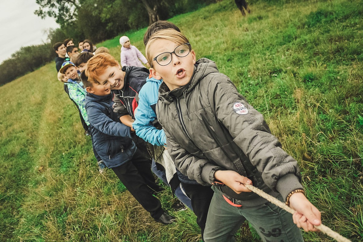 Children playing tug of war at summer camp