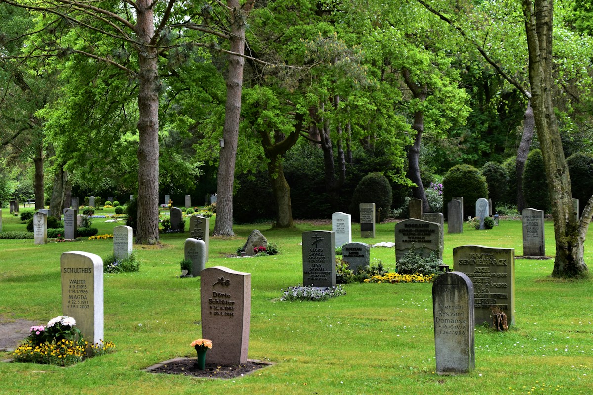Cemetery grounds with a stone cross on green grass