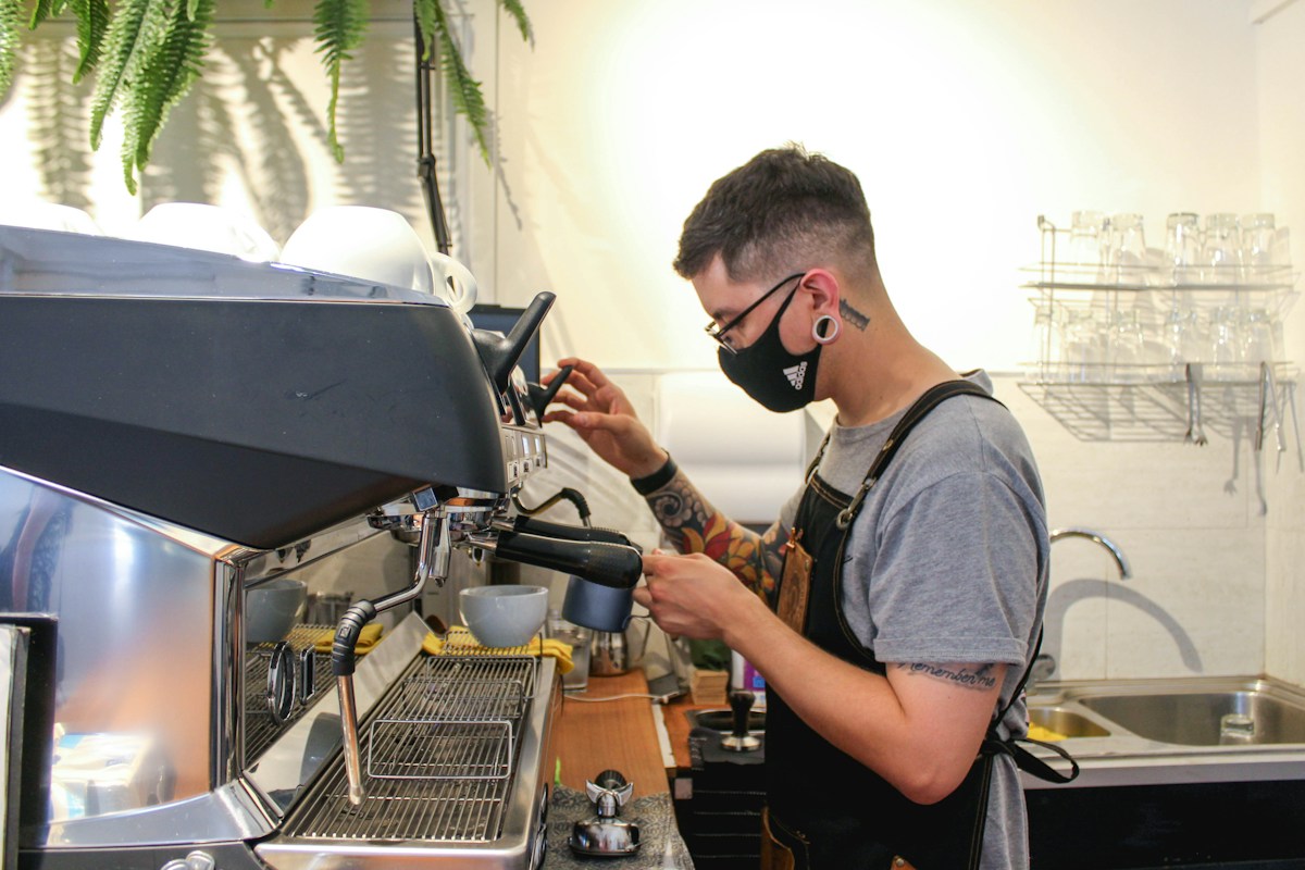Barista using an espresso machine in a coffee shop