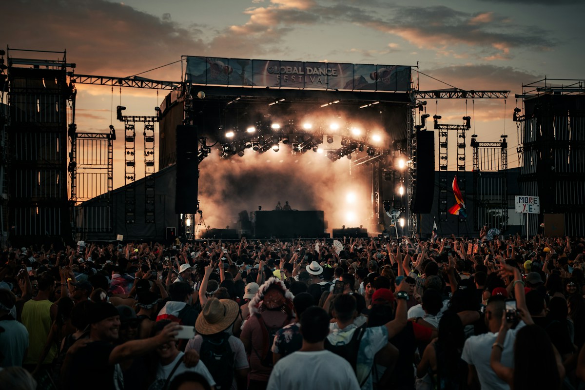 Crowd watching an outdoor festival stage during daytime