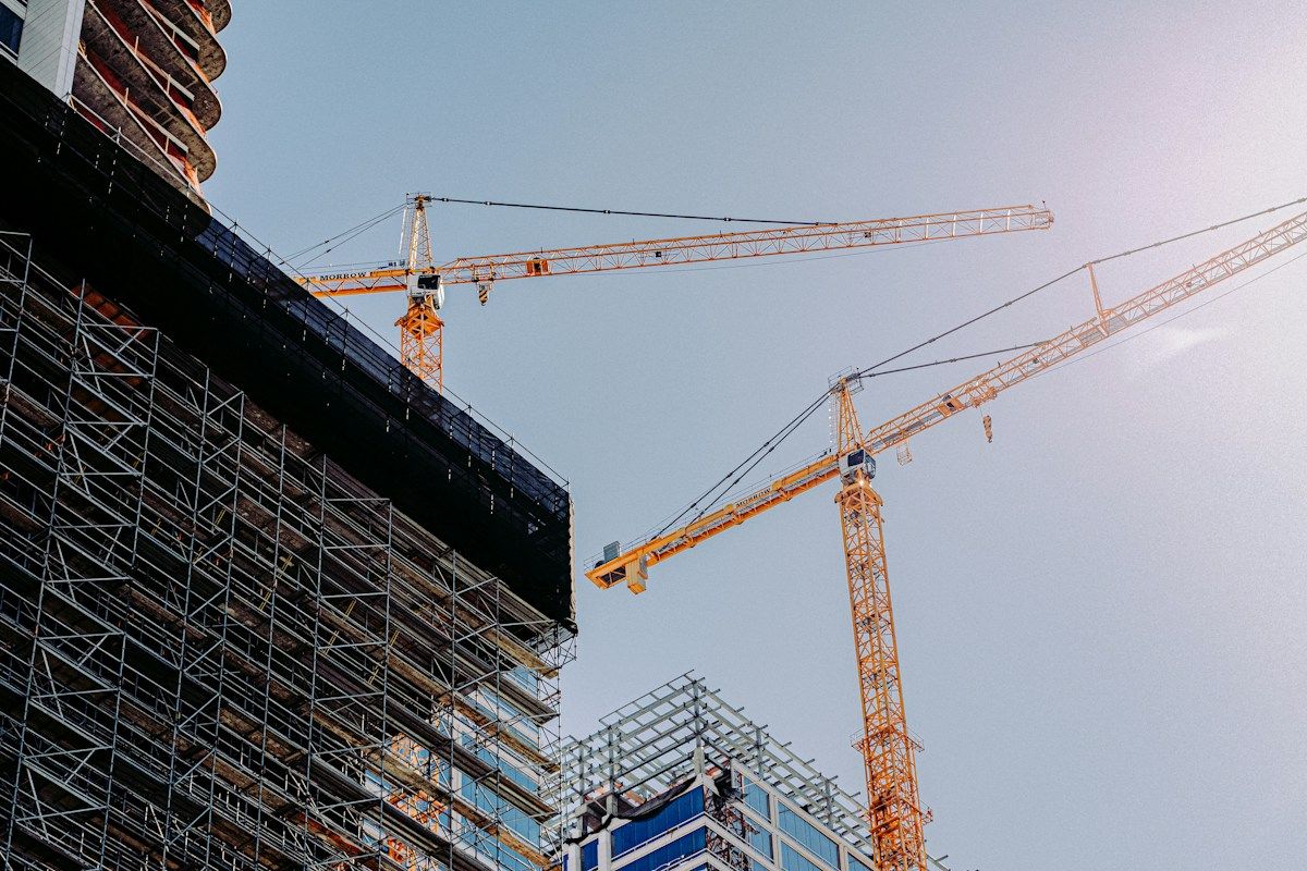 Yellow construction crane near a building during daytime