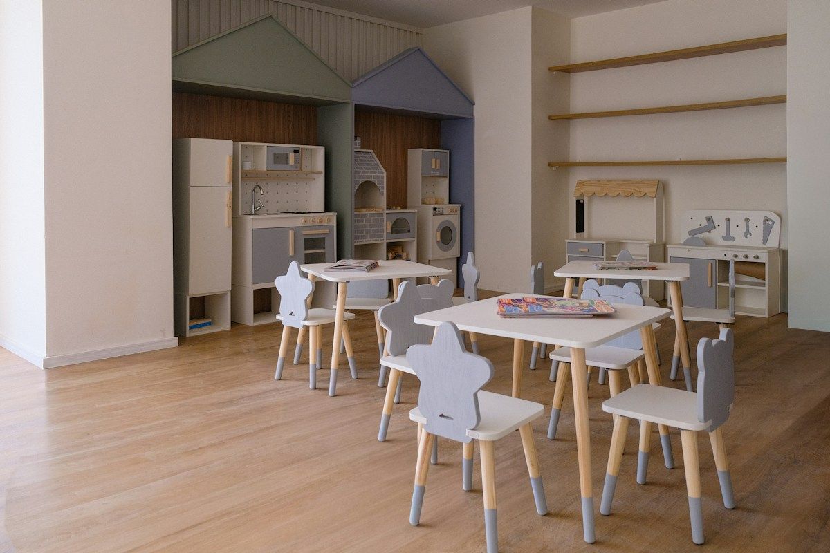 Children daycare playroom with small tables and chairs