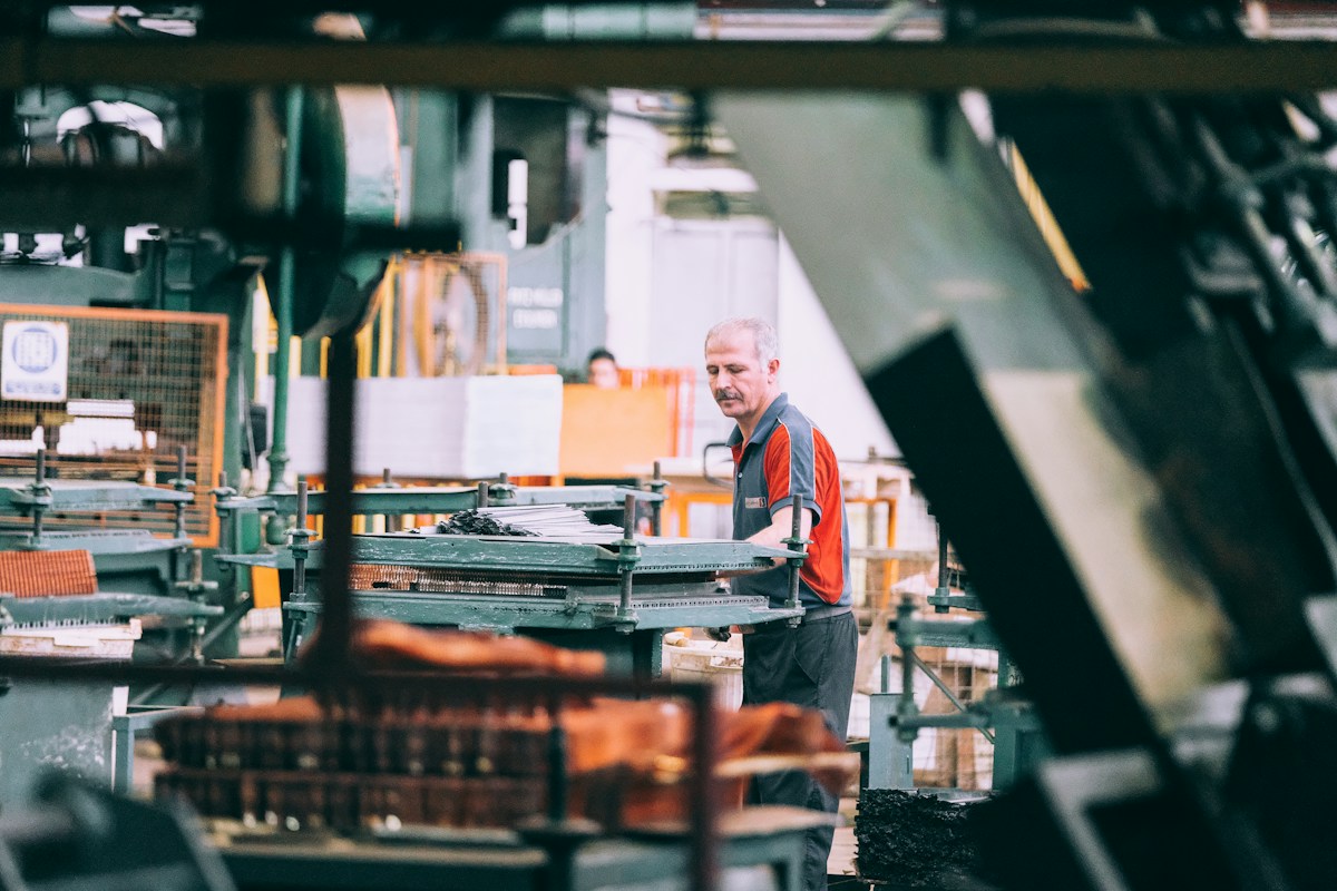 A worker operating industrial machinery in a factory