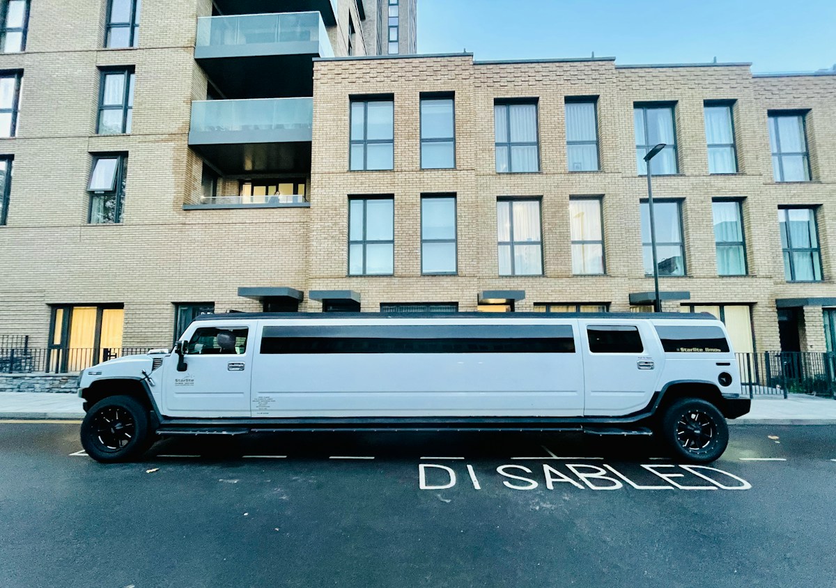 A white limousine parked in front of a building