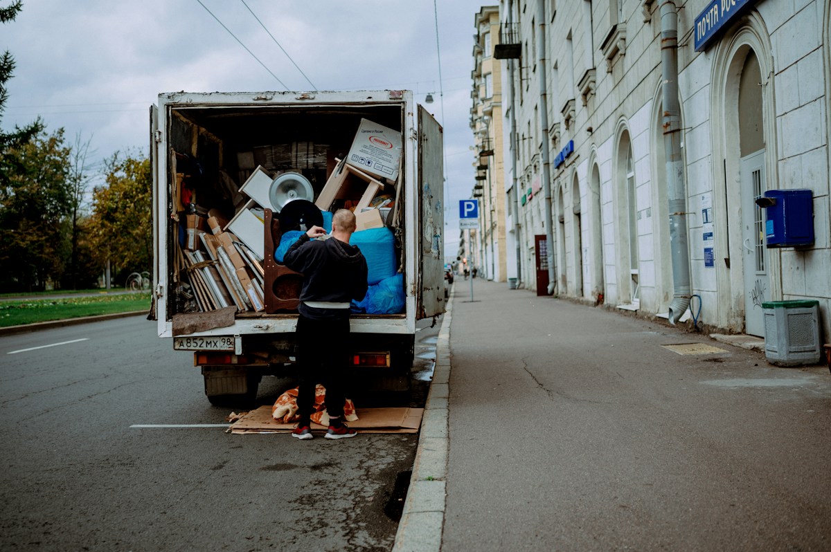 A mover unloading furniture from the back of a moving truck