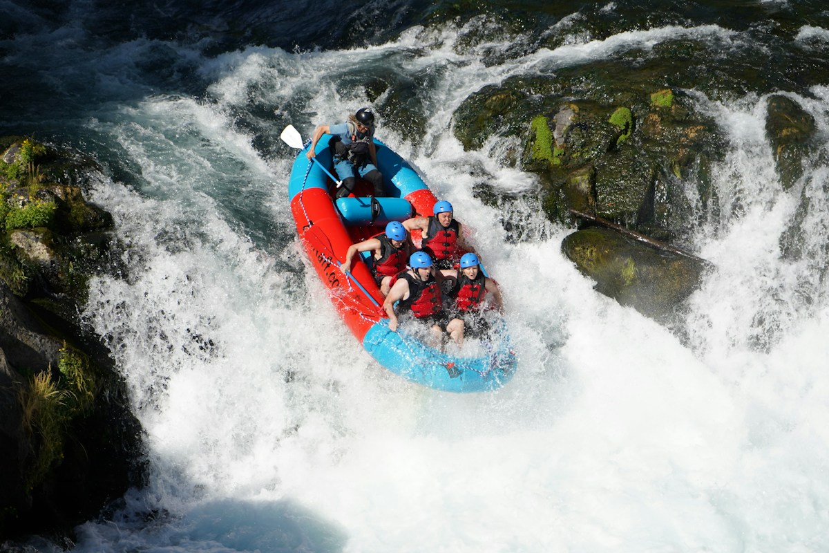 People whitewater rafting down a rocky river