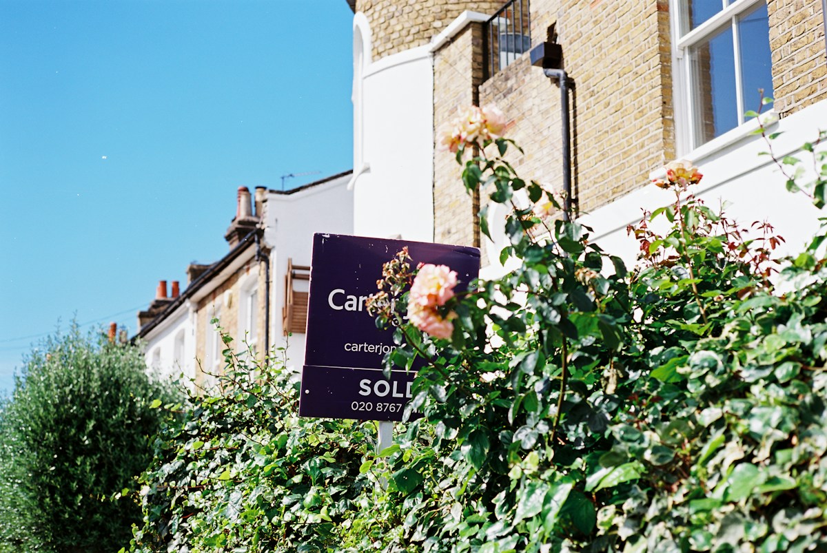 A real estate sign in front of a house