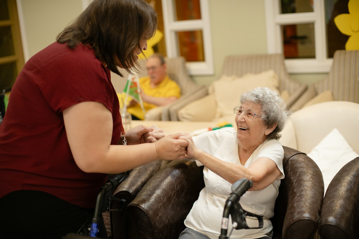 Caregiver assisting an elderly woman with a walker