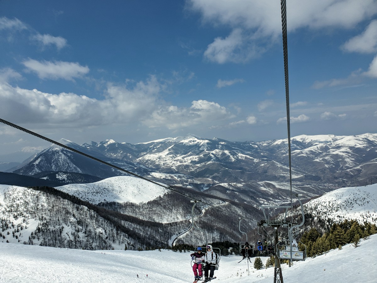 Skiers riding a chairlift on a snow covered mountain