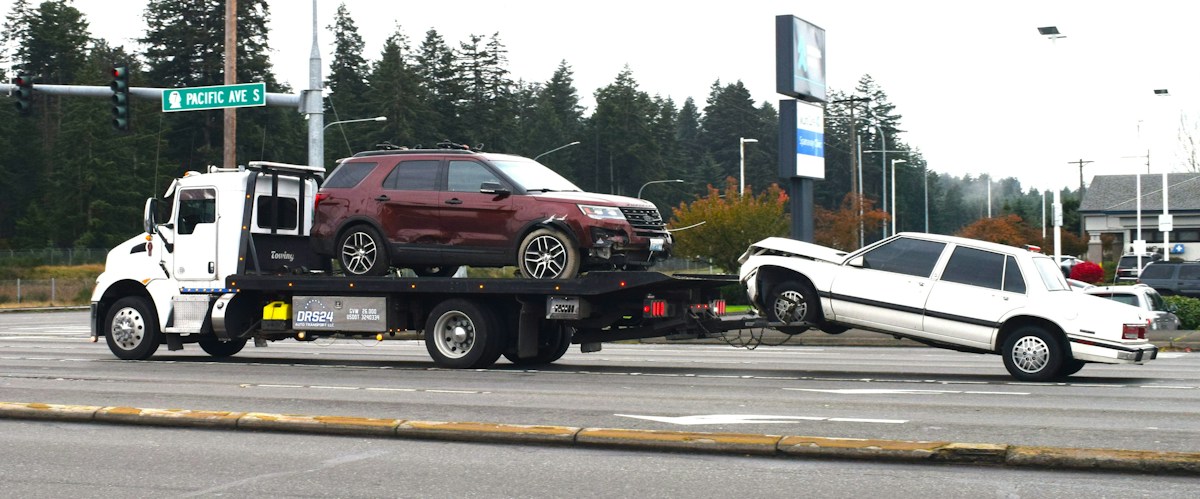 A tow truck carrying a car on a flatbed