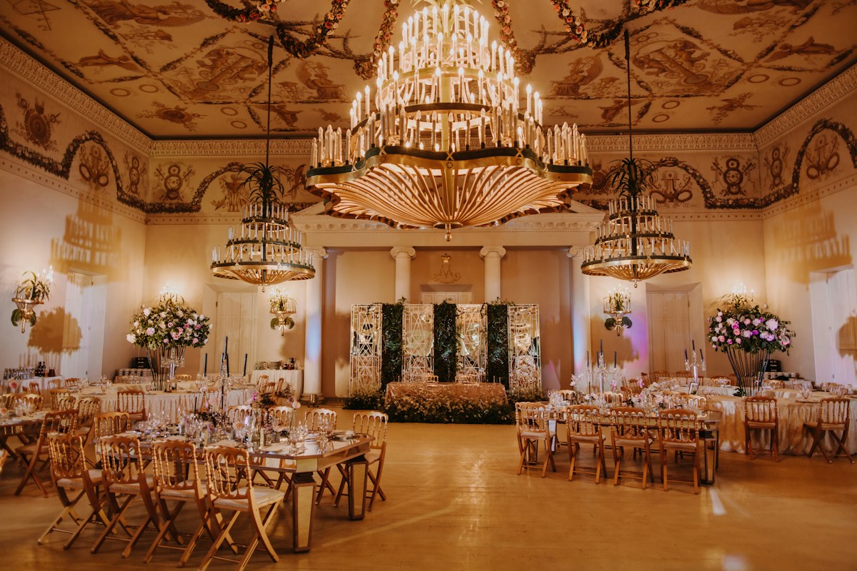 A wedding reception banquet hall with chandeliers and tables