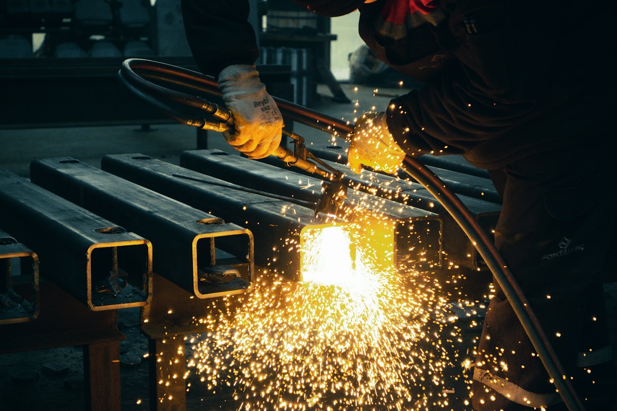 Welder working on a piece of metal in a factory