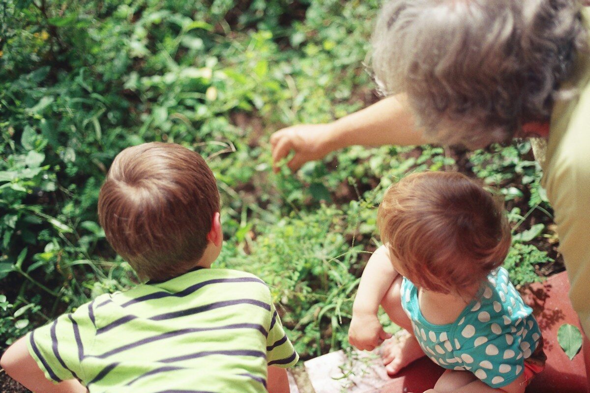 Caregiver playing with children outdoors